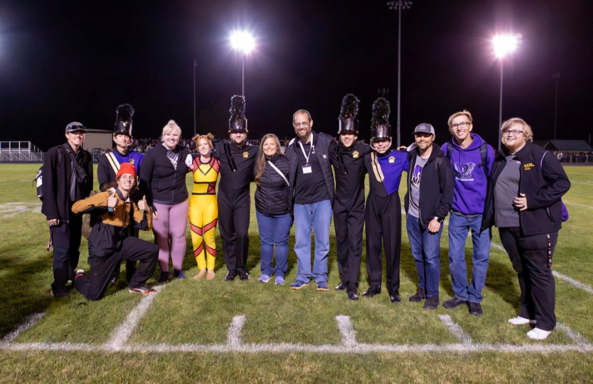 Rocky Mountain High School's teachers and heads of the marching band pose for a photo at a district competition. 