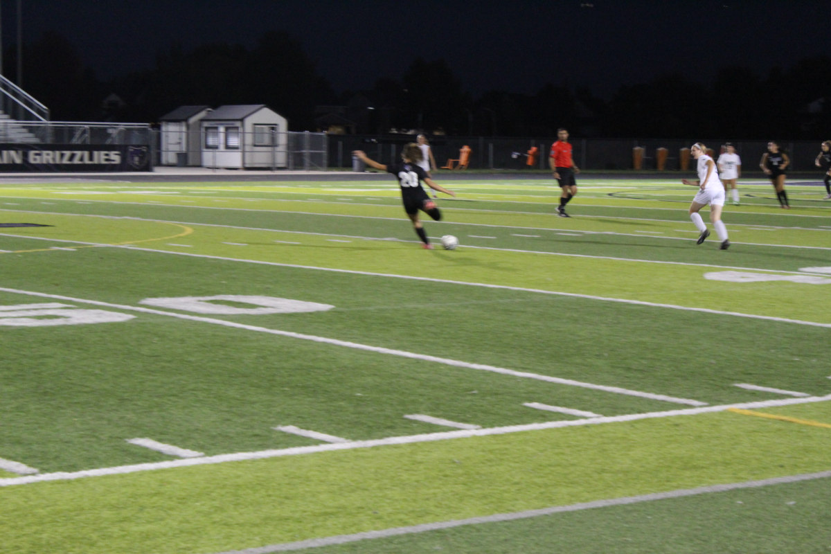 Number 20 for Rocky Mountain kicking the soccer ball at the game.