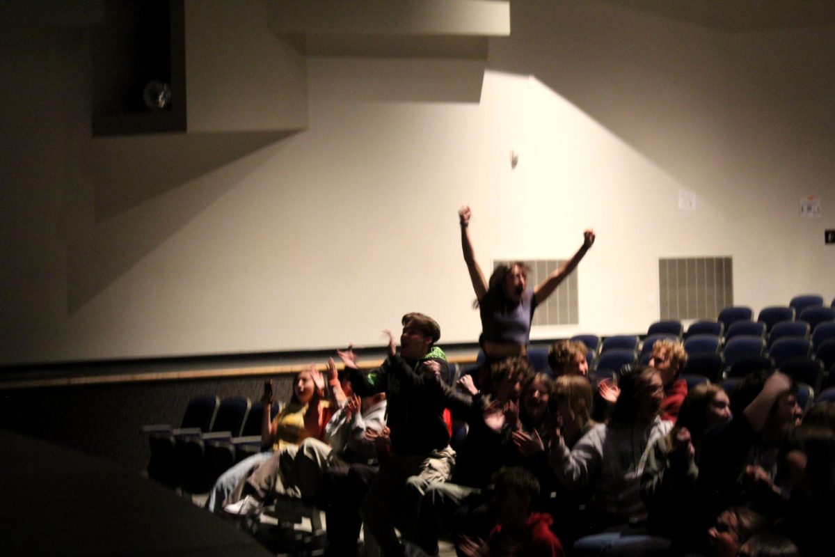 The auditorium erupts into cheers