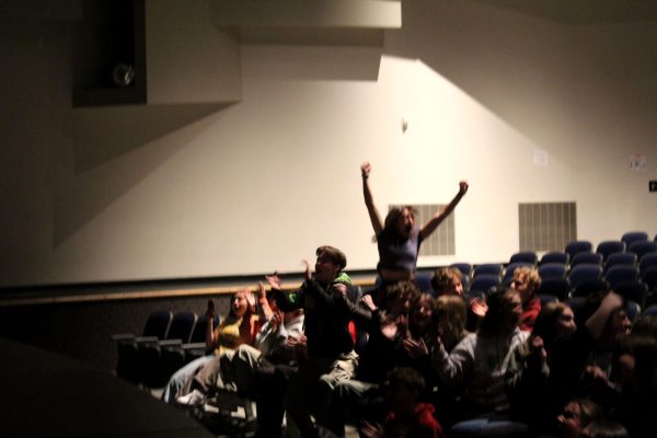 The auditorium erupts into cheers